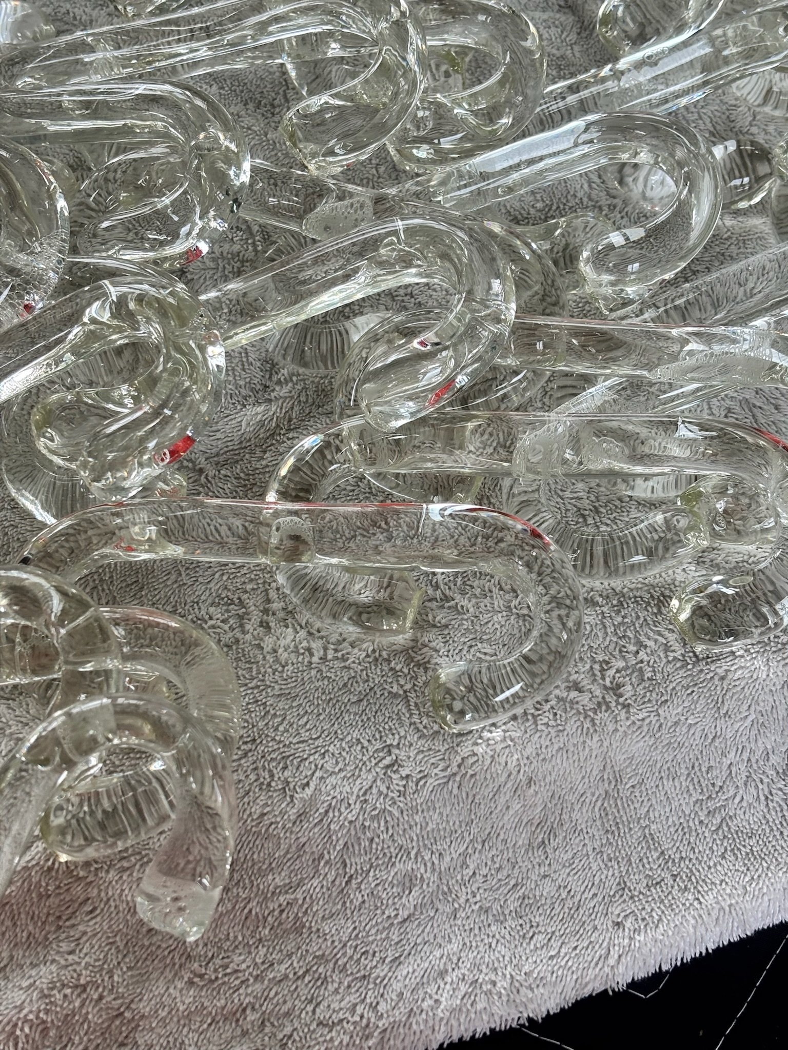 Handblown glass chain links spread on towel during hand-cleaning process
