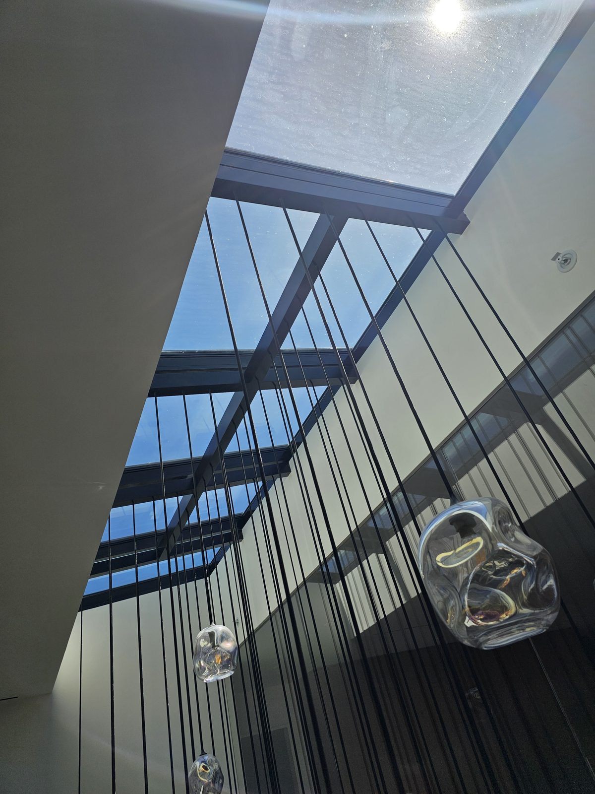 Glass pendant cables and stair railing from staircase level during cleaning