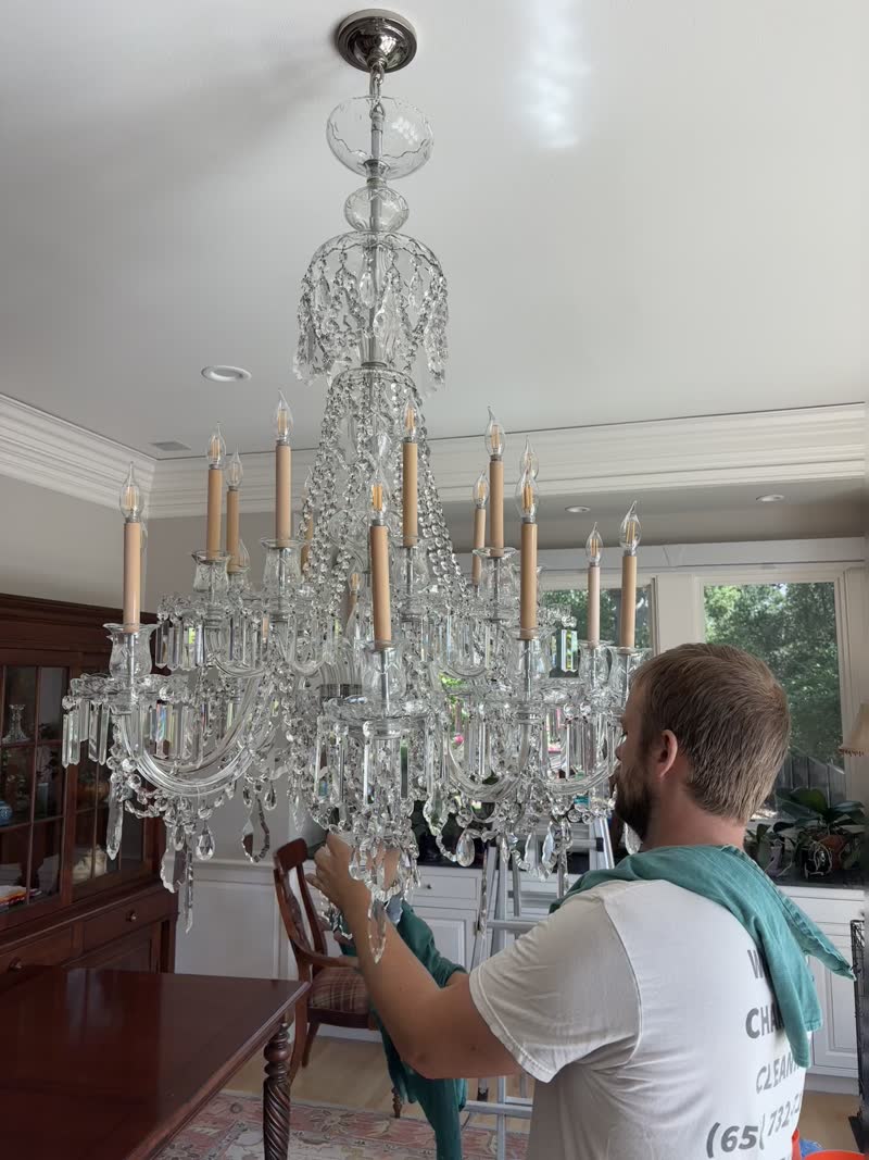 Professional hand-cleaning a Baccarat crystal chandelier pendant by pendant