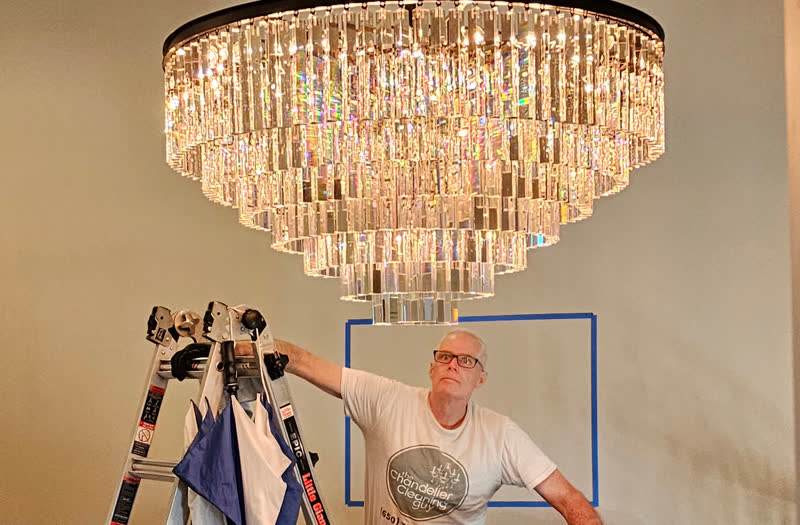 Restoration Hardware chandelier being gently wiped with a soft dry cloth