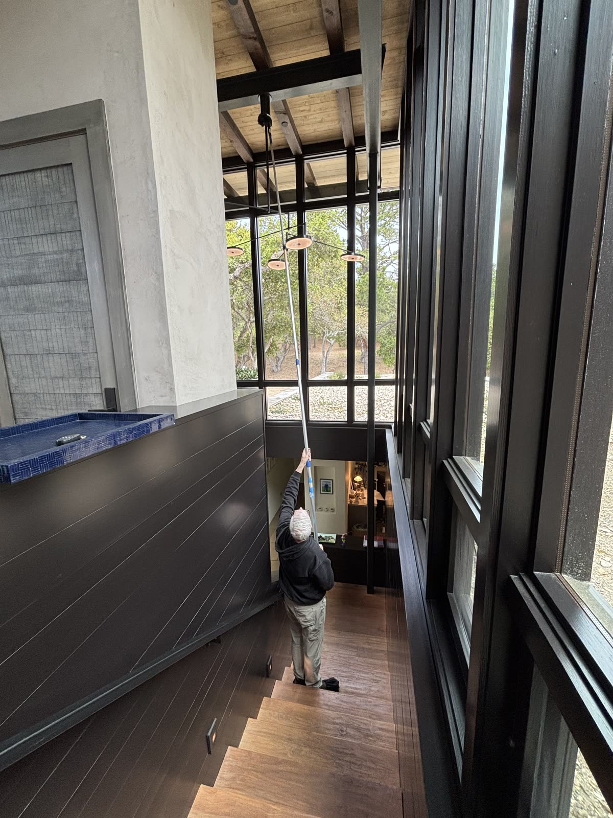 High dusting pendant lights in a two-story entryway with extension pole