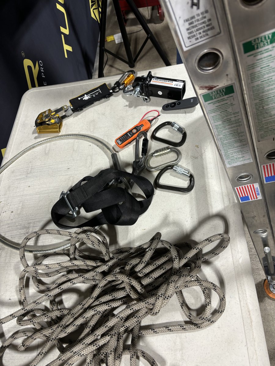 Professional safety equipment: carabiners, harness, and rope for fall protection